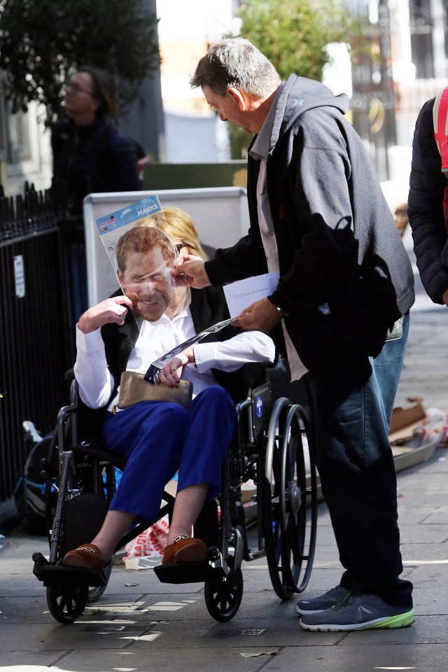 The American held up the paper mask of Prince Harry to her face