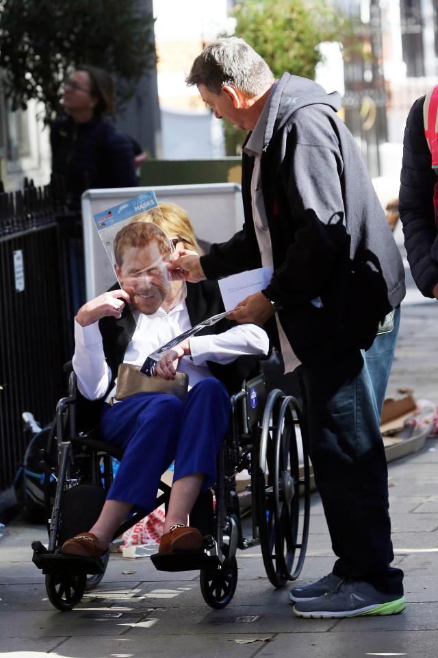  The American held up the paper mask of Prince Harry to her face