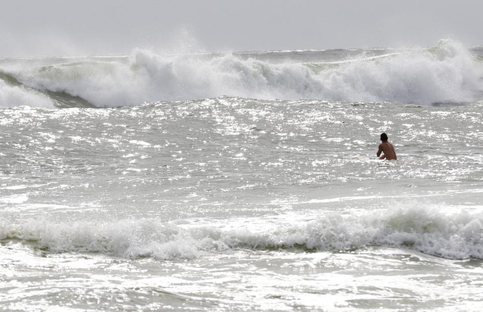 The surfer tries to catch the growing waves before the storm hits