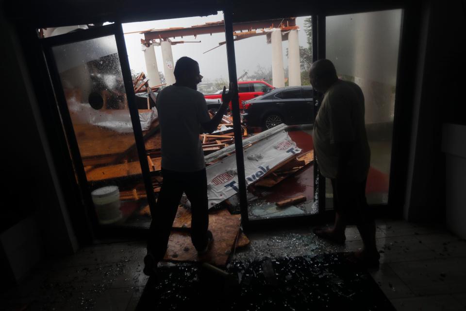  Hotel employees inspect a canopy which collapsed as Hurricane Michael passed through Panama City Beach, Florida