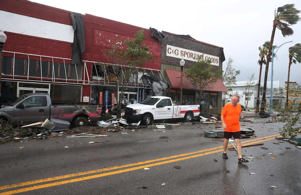  Mike Hays walks past local stores torn apart by Hurricane Michael