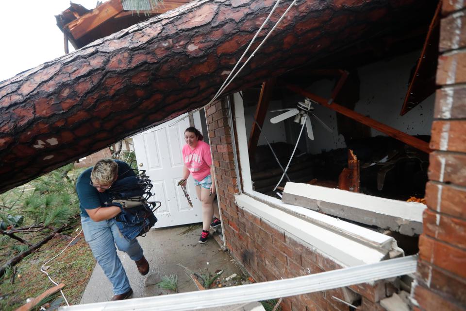  Megan Williams, left, and roommate Kaylee O'Brian rescue belongings from their destroyed home