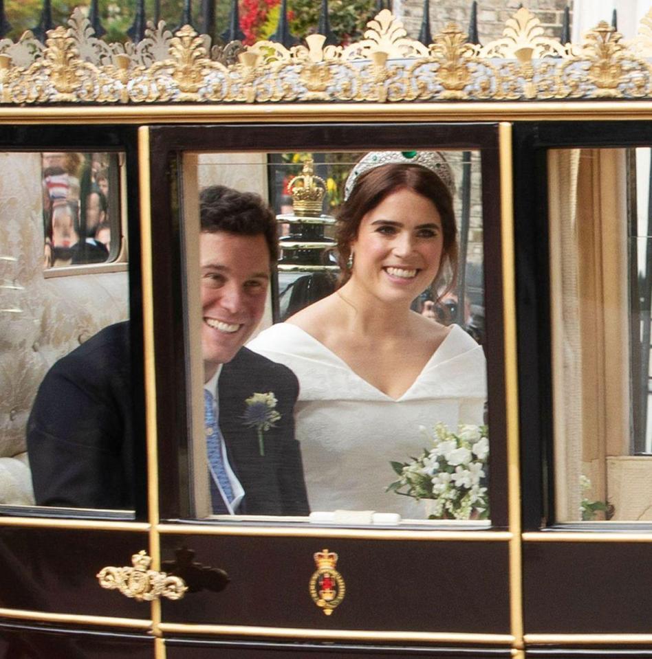  The couple peer out of the carriage at crowds, with Princess Eugenie wearing a tiara gifted to her by the Queen