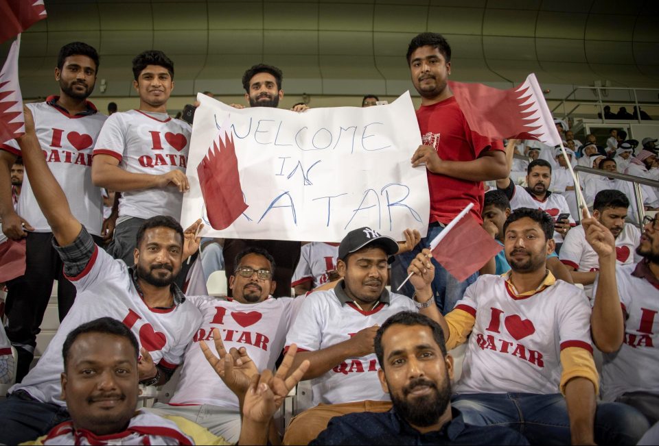 Limousine driver Jahed Mohammed, 23, right. originally from Bangladesh is part of a group holding a banner saying: Welcome in Qatar