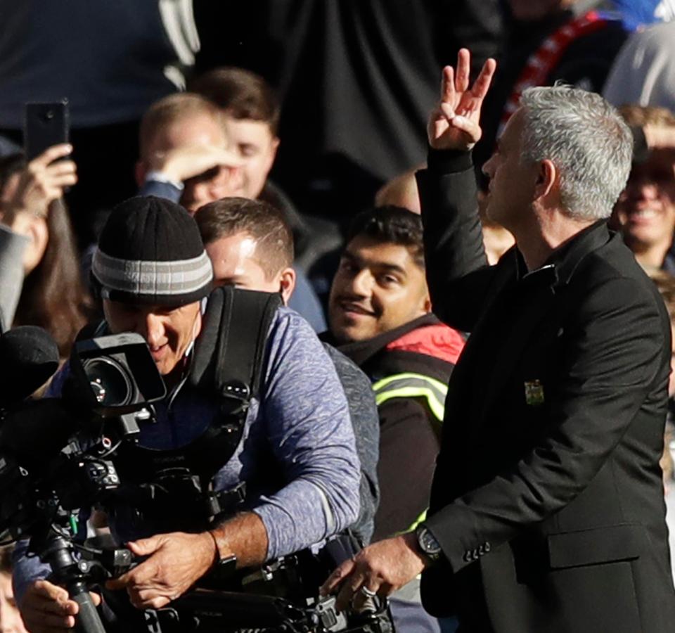  Mourinho holds up three fingers to the Chelsea fans following the full-time whistle