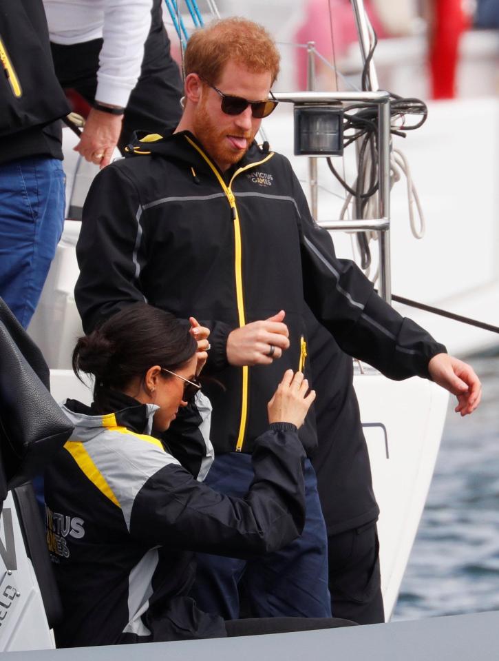  Prince Harry sticks out his tongue as he clambers over the boat