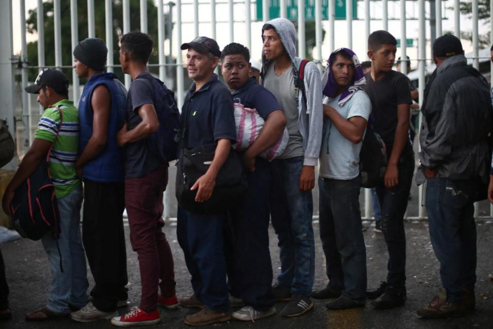  Migrants line up as they wait to open the gate on the bridge that connects Mexico and Guatemala in Ciudad Hidalgo, Mexico