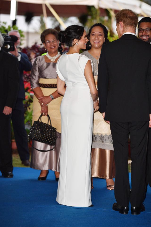  Meghan stunned in the sleek white full-length gown with detailing on the shoulders at the pair attended dinner at the palace in Nuku'alofa