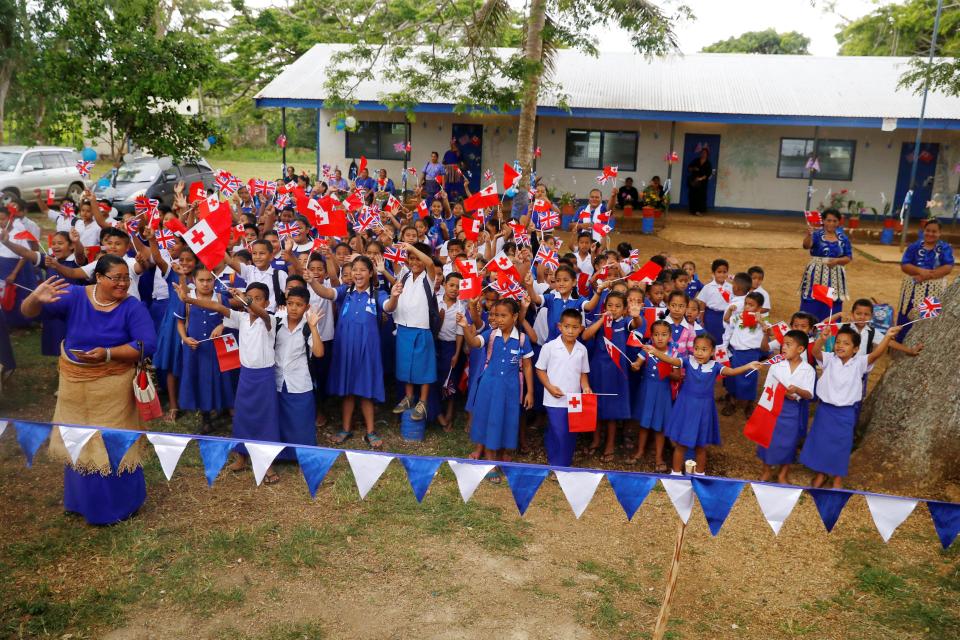  Schoolchildren cheer on the side of the road as royal motorcade carrying Meghan and Prince Harry