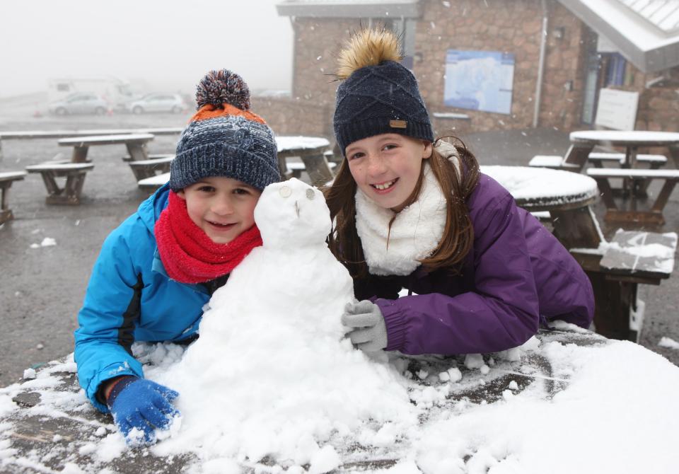  Two children play in the snow today in Glemore in the Highlands