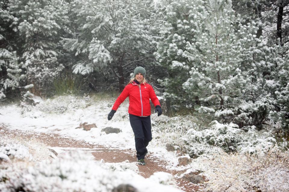  A woman walking in the fresh snow today in Glenmore in the Scottish Highlands