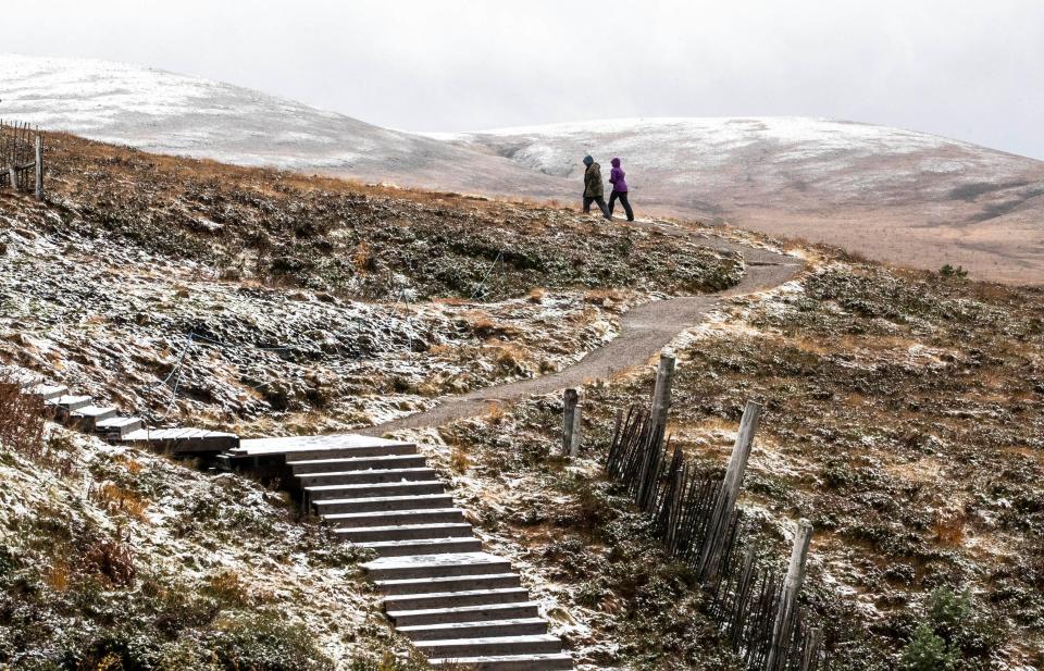  A couple walk through the early winter snow today in the Cairngorms near Aviemore in the Highlands