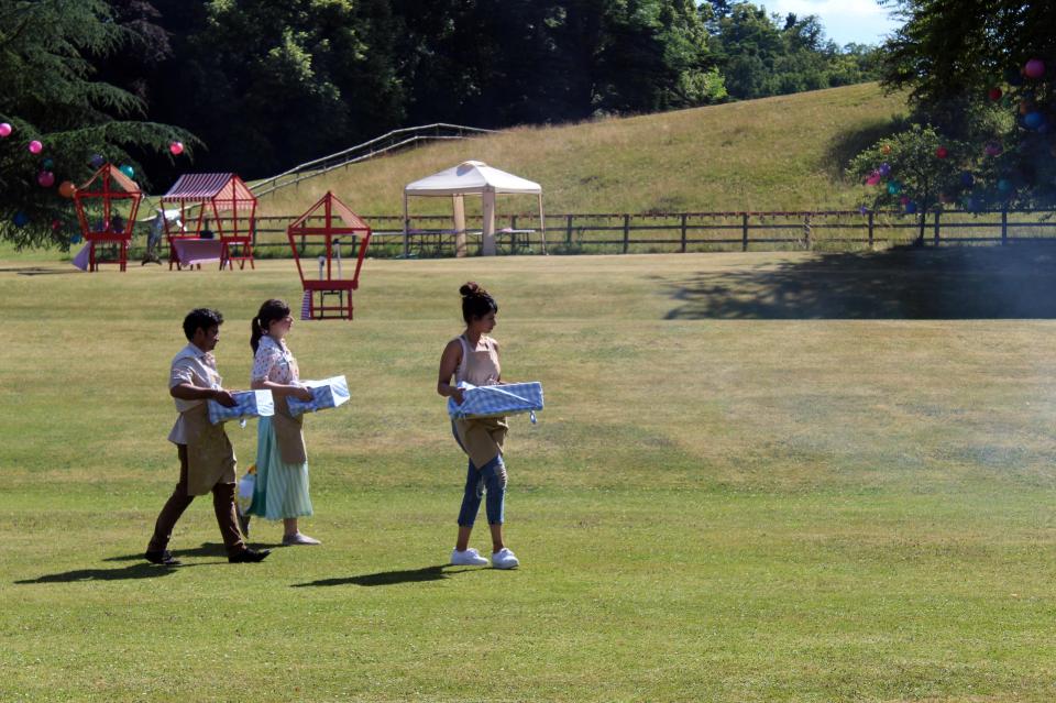  Rahul Mandal, Kim-Joy Hewlett and Ruby Bhogal carrying their wares to bake without their usual fancy kitchen equipment