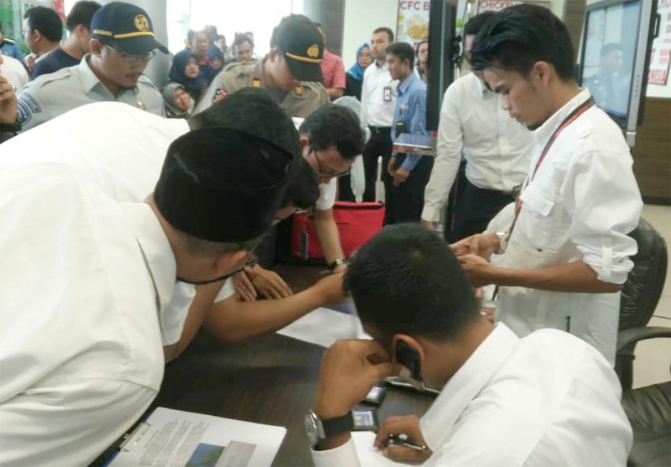 Lion Air officials check the passenger list of Lion Air flight JT610 that crashed into the sea