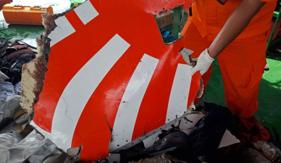 Rescue workers display a piece of wreckage from Lion Air flight JT 610