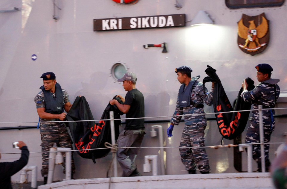 Emergency workers carry body bags near the scene of where the Lion Air jet plunged into the sea