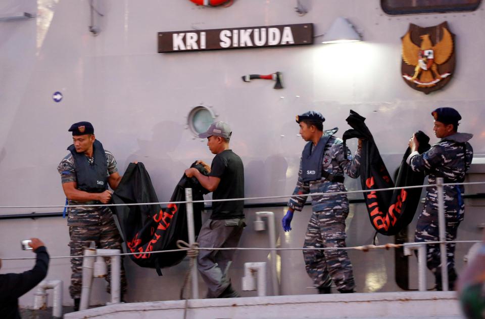  Emergency workers carry body bags near the scene of where the Lion Air jet plunged into the sea