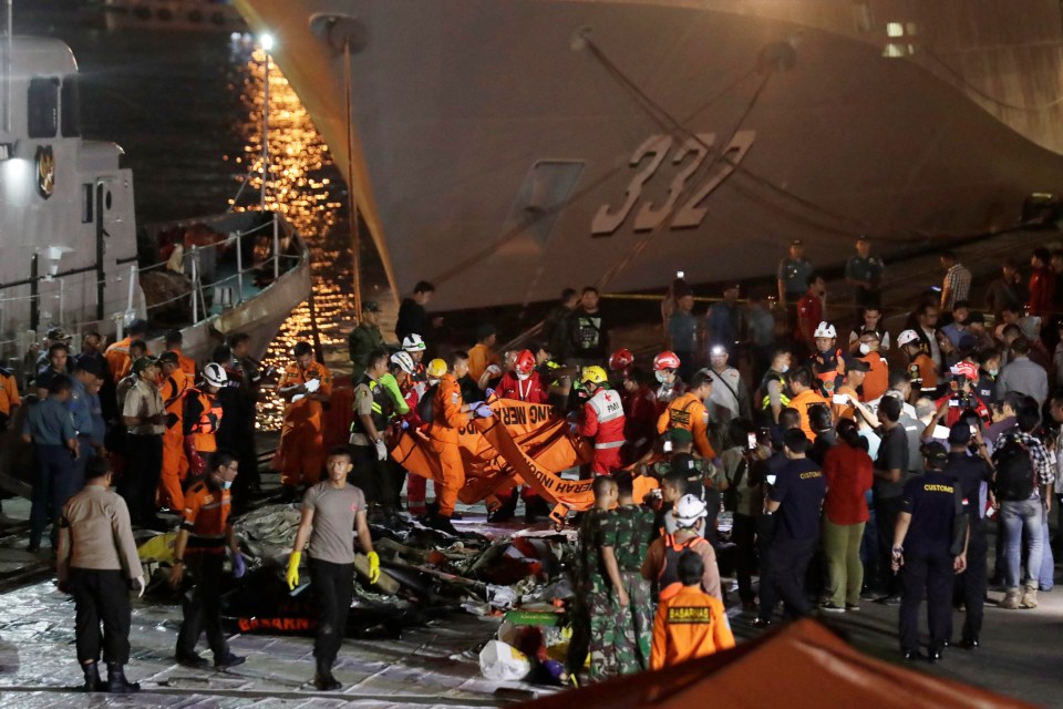 Indonesian rescue team members evacuate bodies of the plane crash victims at Tanjung Priok Harbour