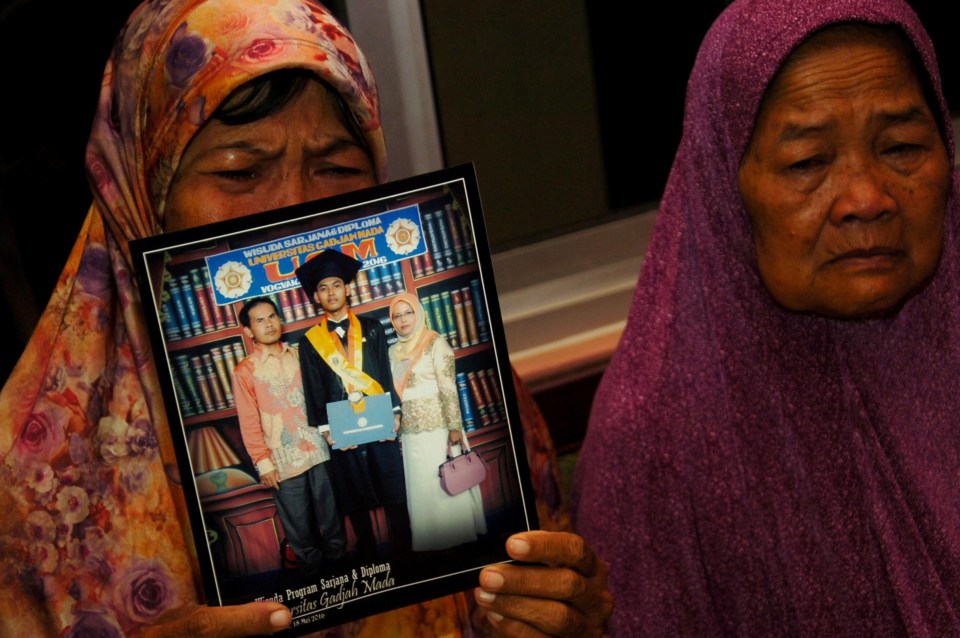 A crying mother shows a graduation picture of her son, Agil Nugroho Septian, who was a passenger on the doomed Lion Air flight JT610