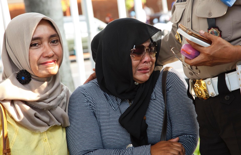 A woman whose relative was on flight JT 610 is comforted by a police officer at Soekarno Hatta Airport