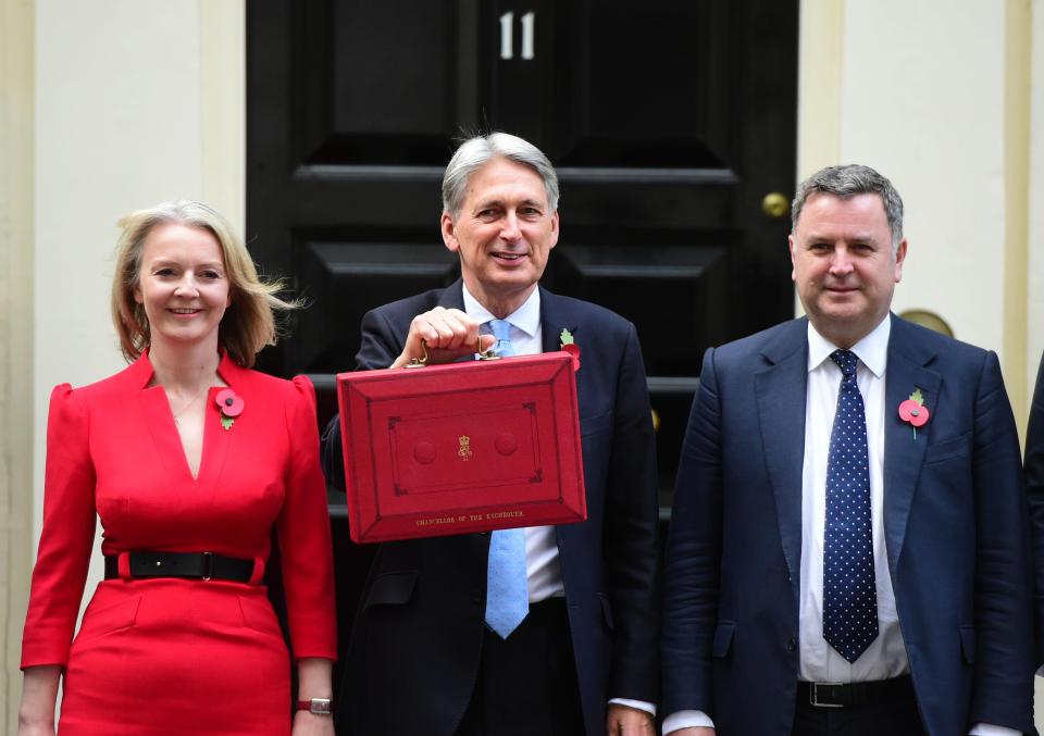  The Chancellor holds his red ministerial box outside 11 Downing Street, London, alongside Treasury colleagues Liz Truss (left) and Mel Stride