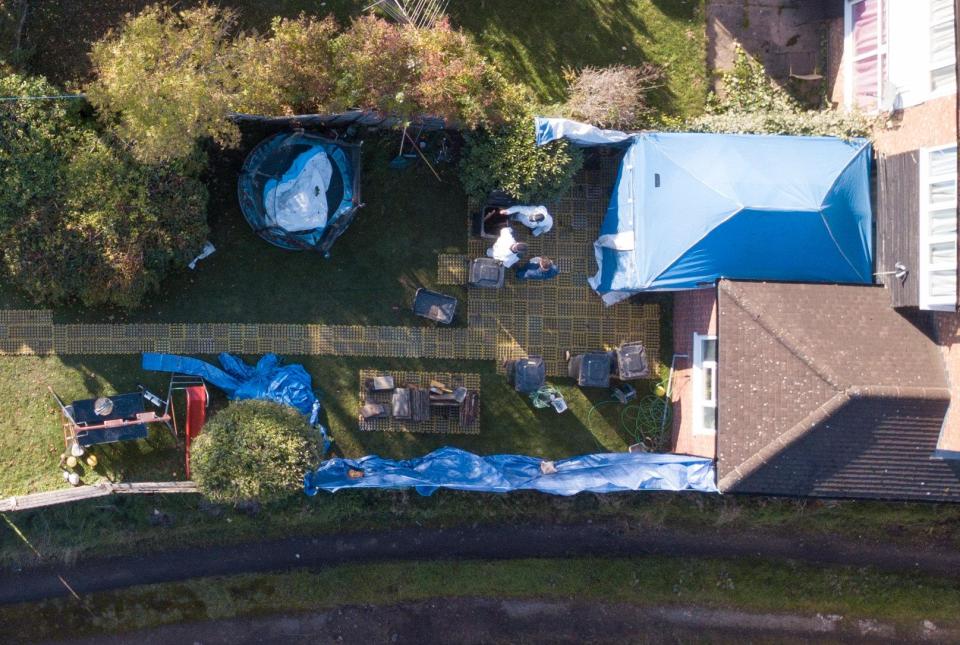 Forensic police can be seen erecting a tent outside the kitchen window of John Cannan's mother's previous home