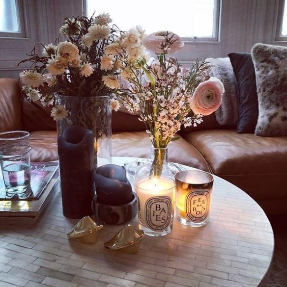  Stacey's living room features vases filled with fresh flowers, and an array of candles