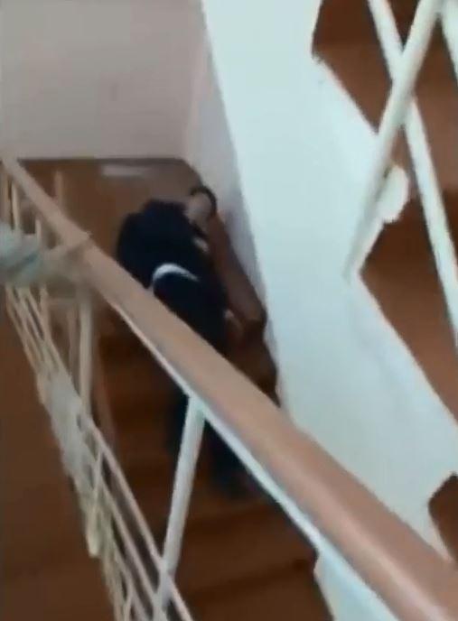 A teenager lays on the stairs wounded after being shot by his fellow student