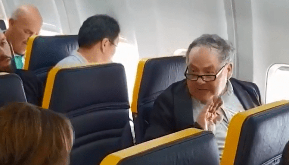  The man gestures angrily as he orders the woman to move seats