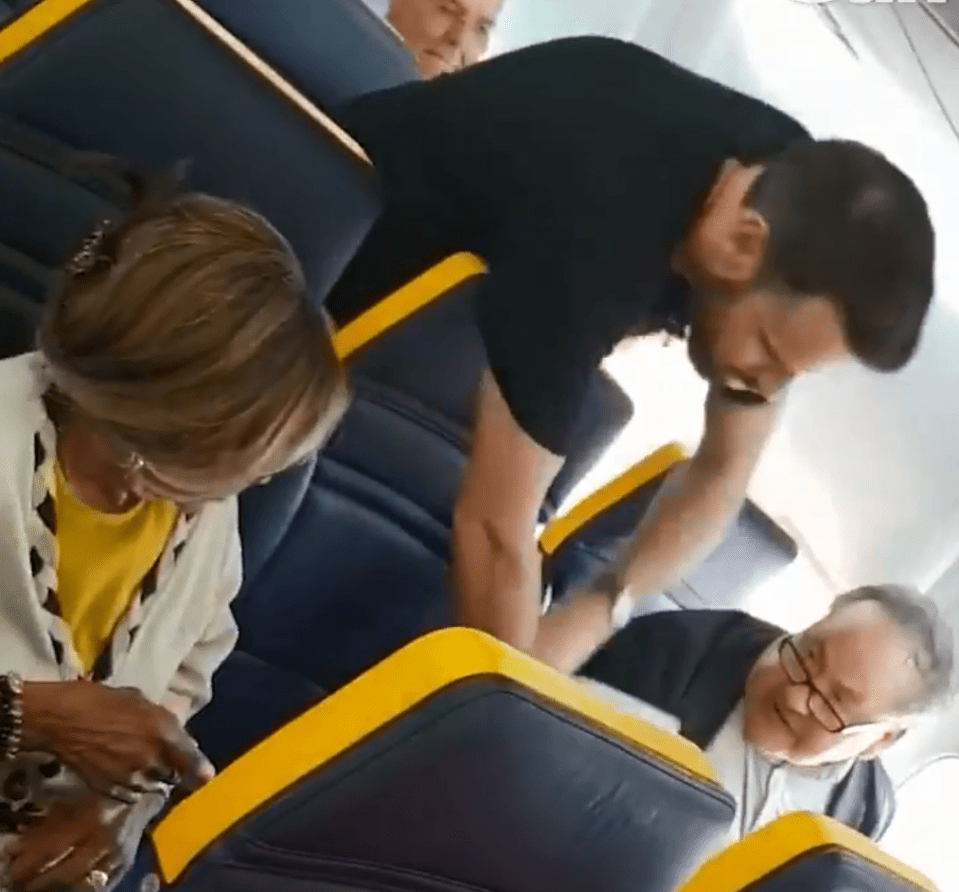  A passenger is seen trying to intervene as a man abuses the passenger seated near him on the flight