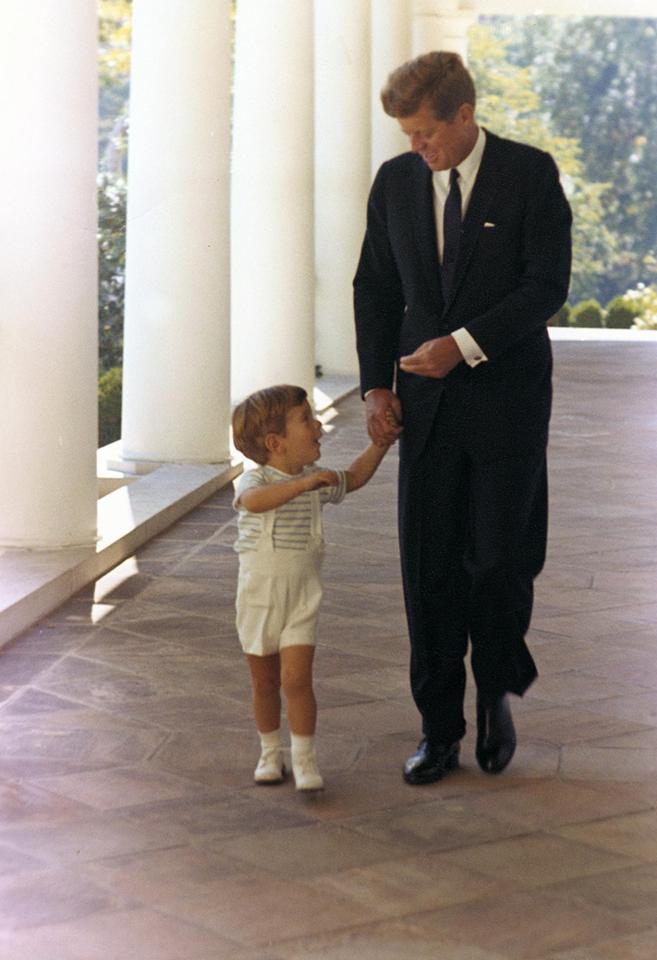 President John F Kennedy and John Jr walk together in the West Wing Colonnade of the White House on October 10, 1963