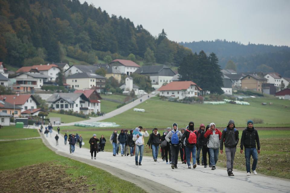  Migrants who had arrived via buses chartered by Austrian authorities walk towards the border to Germany on October 17, 2015 near Mistlberg, Austria