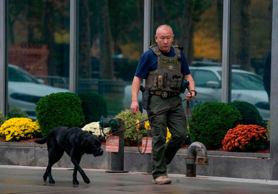  A member of the US Marshal walks with his dog outside the court