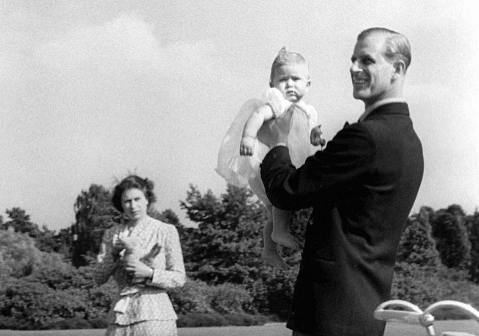  1949: Prince Charles being lifted up by his father The Duke of Edinburgh, in the grounds of Windlesham Moor