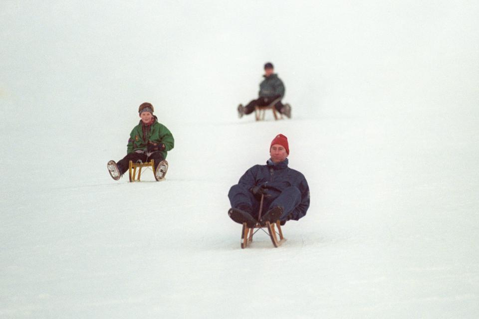  1995: Charles followed by his sons Prince Harry and Prince William, during a toboggan race on the slopes outside their hotel in the Swiss resort of Klosters