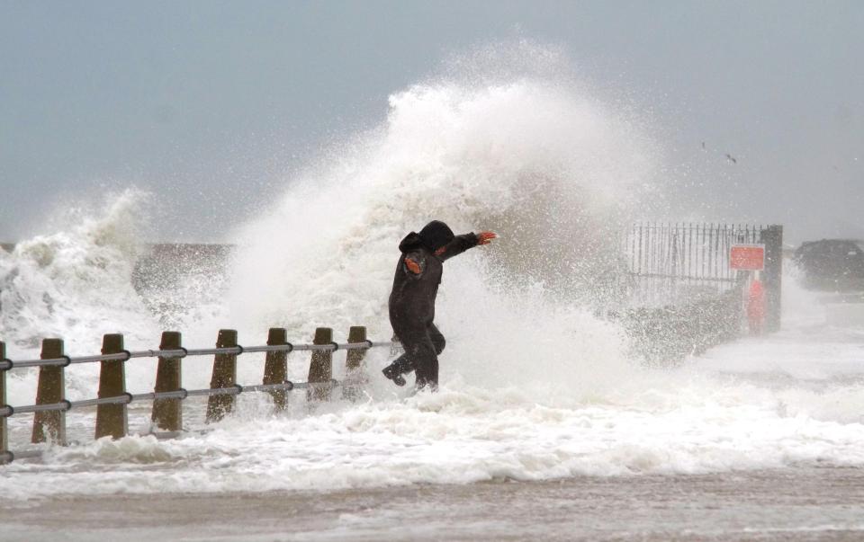  A man risks his life dodging huge waves in Newhaven Harbour, East Sussex, as strong winds whip up the seas at high tide