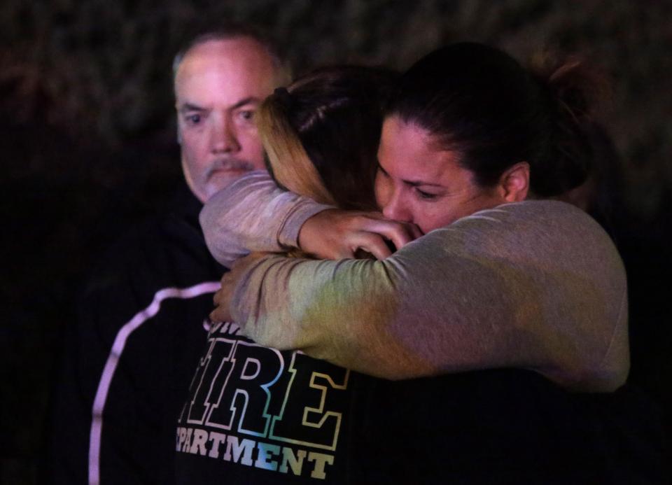  A woman who fled the Borderline bar hugs a loved one following the attack