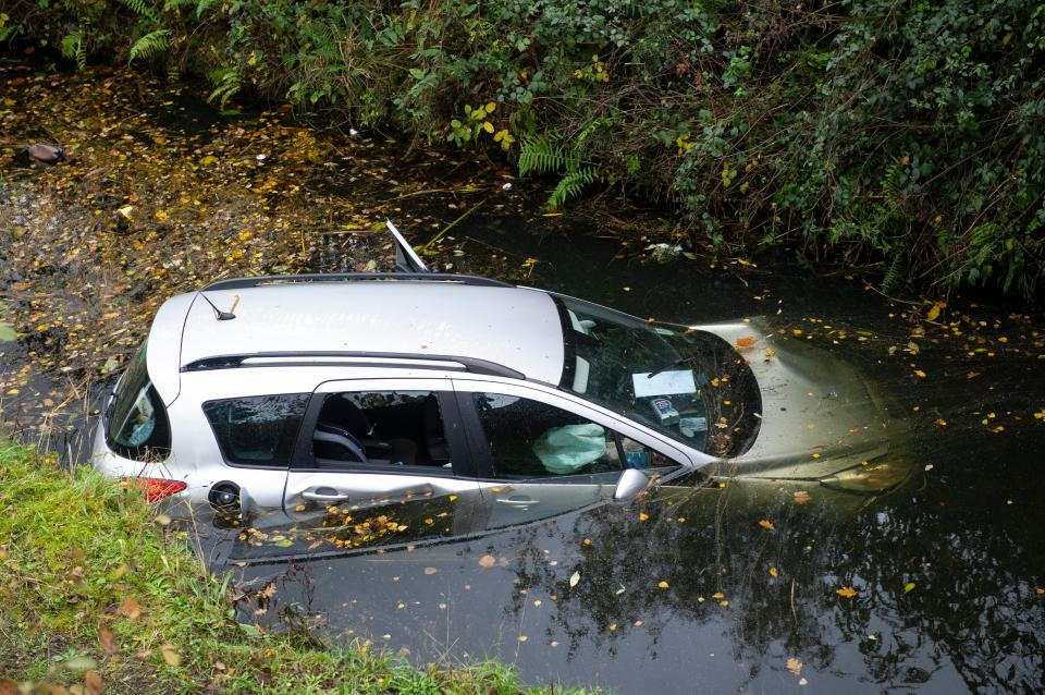  A car is half submerged in a canal by Neath Abbey in south Wales