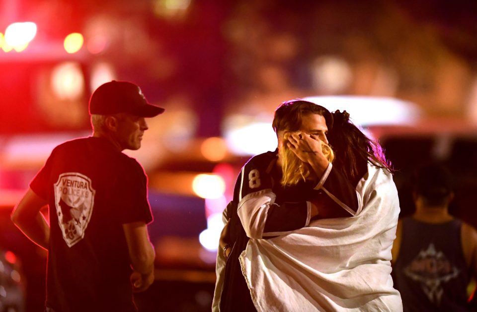  Devastated people embrace after the shooting which left 12 innocent people dead