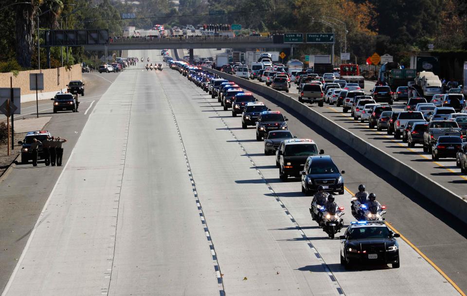  Officers salute at the side of the road as Sgt Helus's body is driven down Ventura HIghway 101