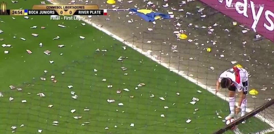 The 25-year-old River Plate midfielder p;aced the ball down to take the corner - but the Boca fans were armed and ready