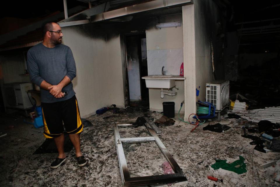  An Israeli man inspects the damage in an apartment that was hit by a rocket fired from the Gaza Strip, in the southern Israeli town of Ashkelon