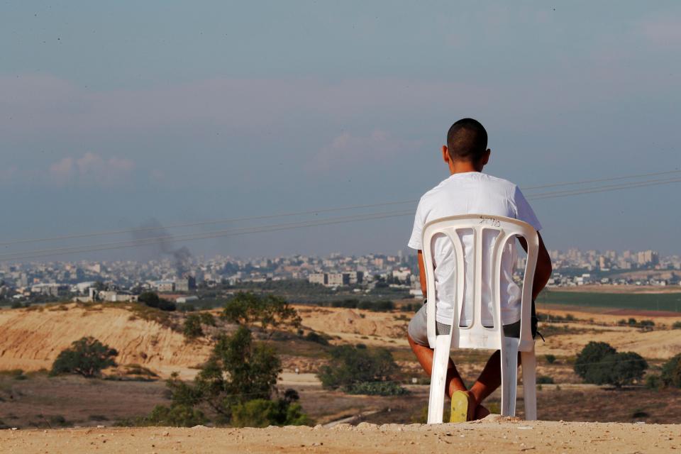  While hundreds of missiles were launched from the Gaza Strip toward Israel, an Israeli man sat on a chair looking towards the border below