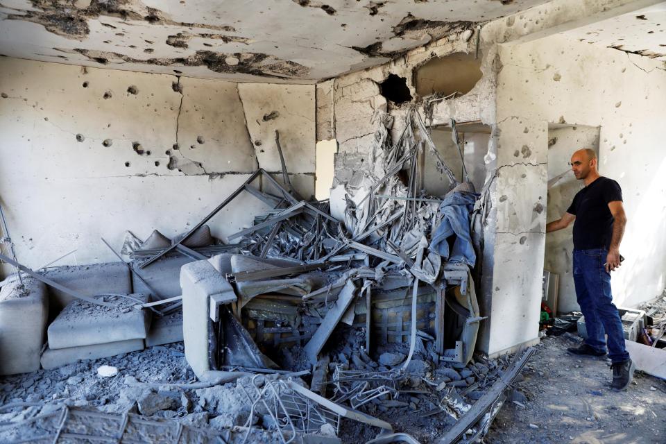  A man stands inside a house damaged by a rocket fired from the Gaza Strip overnight, in the Israeli city of Ashkelon