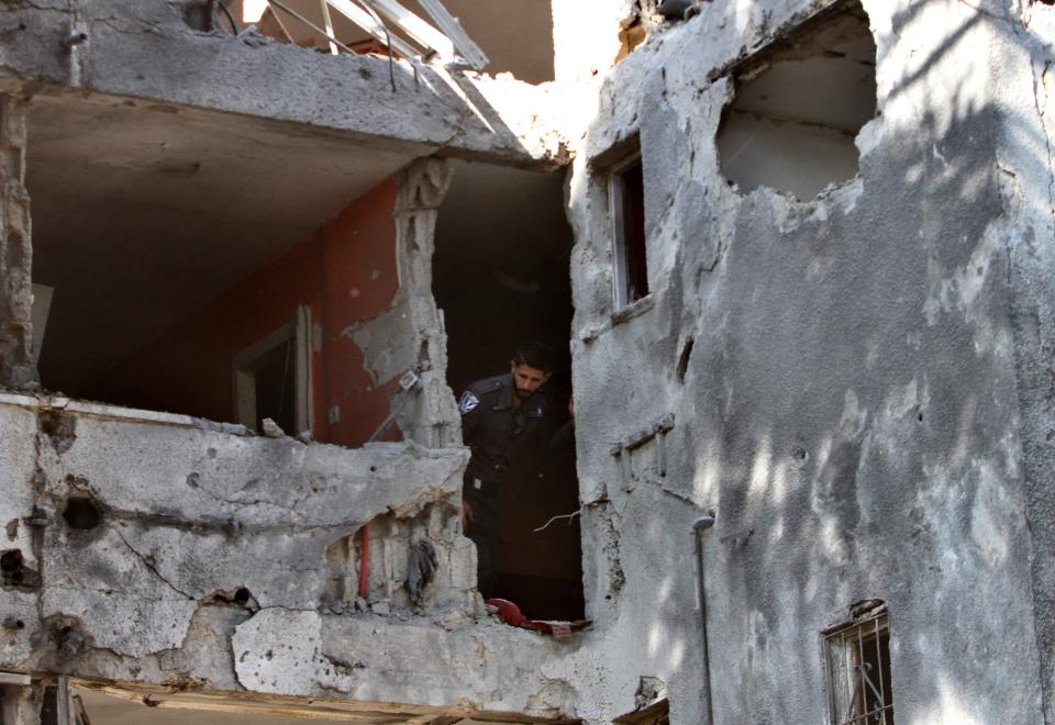  Inspecting a ruined building, an Israeli policeman looks at damage caused by a rocket fired from the Gaza Strip, in the southern Israeli town of Ashkelon, on November 13