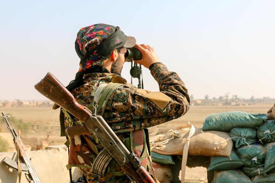  A Syrian soldier keeps a look over miles of wasteland near the Euphrates