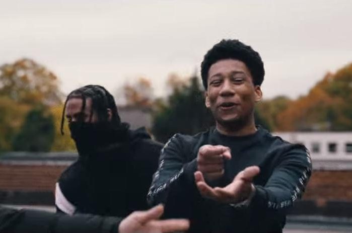  Rhys Herbert, rapping as Digga D, points his hands in a mock gun gesture in a drill rap video