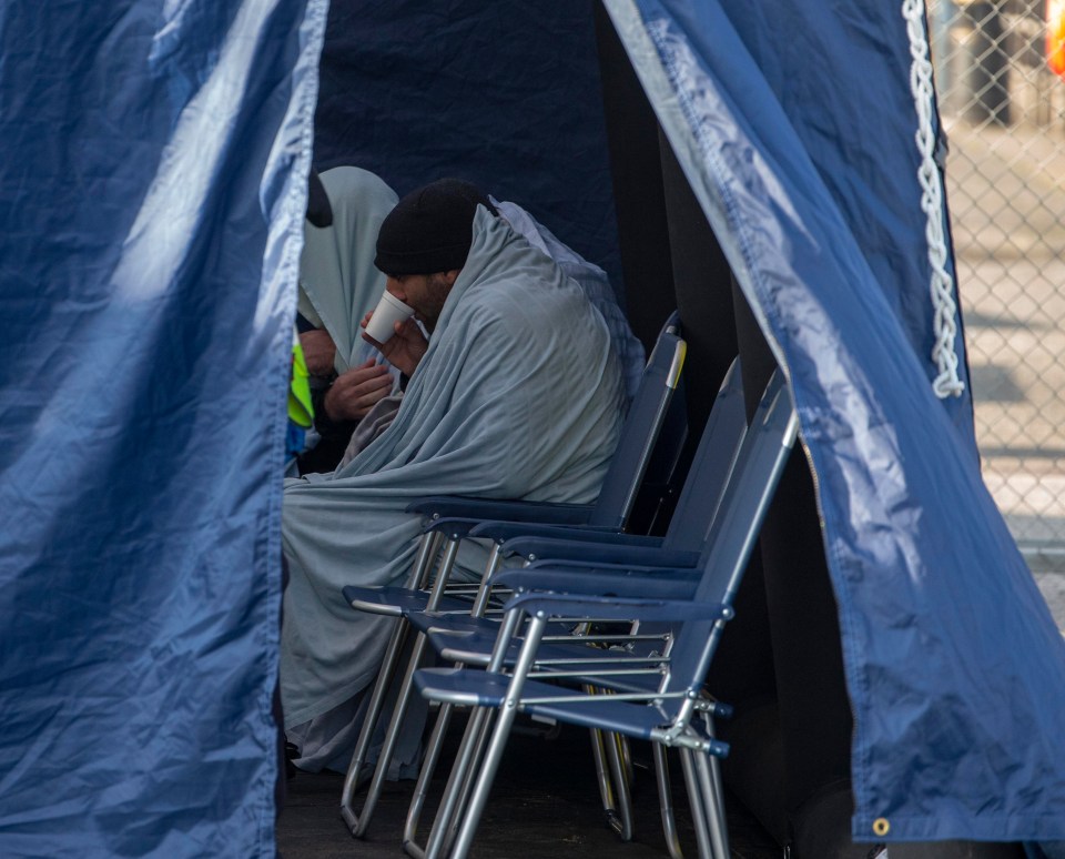 One of the men keeps warm after being rescued in the English channel near Dover