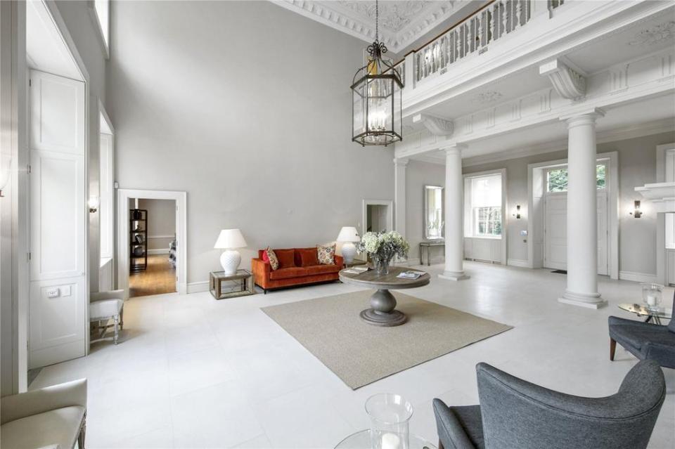  Guests walk into a vast atrium with a high ceiling and white pillars