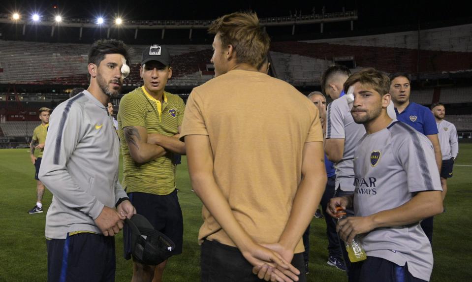 Boca Juniors players in discussion on the pitch as the game is postponed